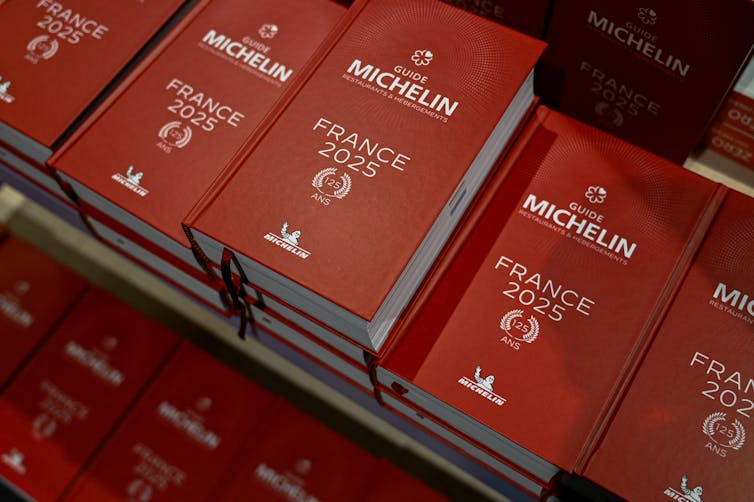 Small stacks of red hardback books that say 'Michelin France 2025'